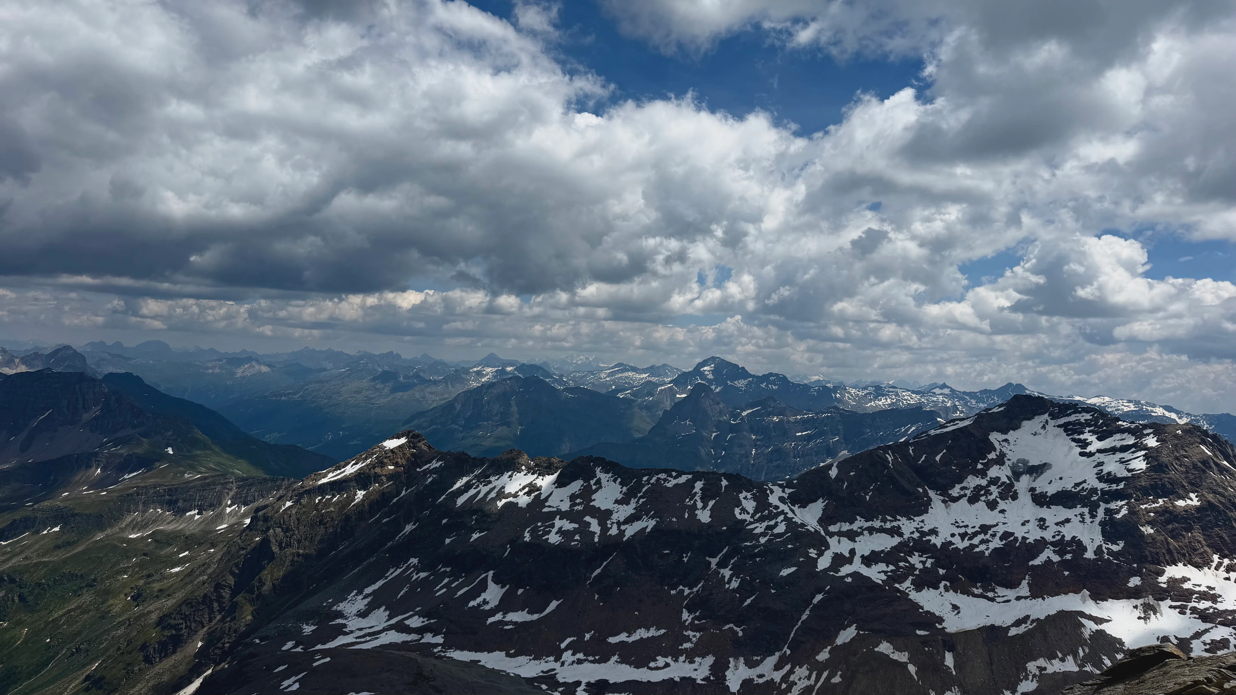 A broad snow-streaked Alpine panorama.